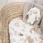 Forest Friends fitted sheet with woodland animals in a wicker basket with a bunny toy