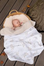 Sleeping baby in a wicker basket under the warm Happy Goose cotton blanket with geese