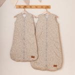 Two beige Herbs sleeping bags with sprig print on a wooden rack