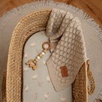 Olive Happy Goose Olive fitted sheet in a wicker Moses basket with a knitted blanket