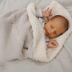 Newborn wrapped in the Bruno blanket in warm beige with soft sherpa