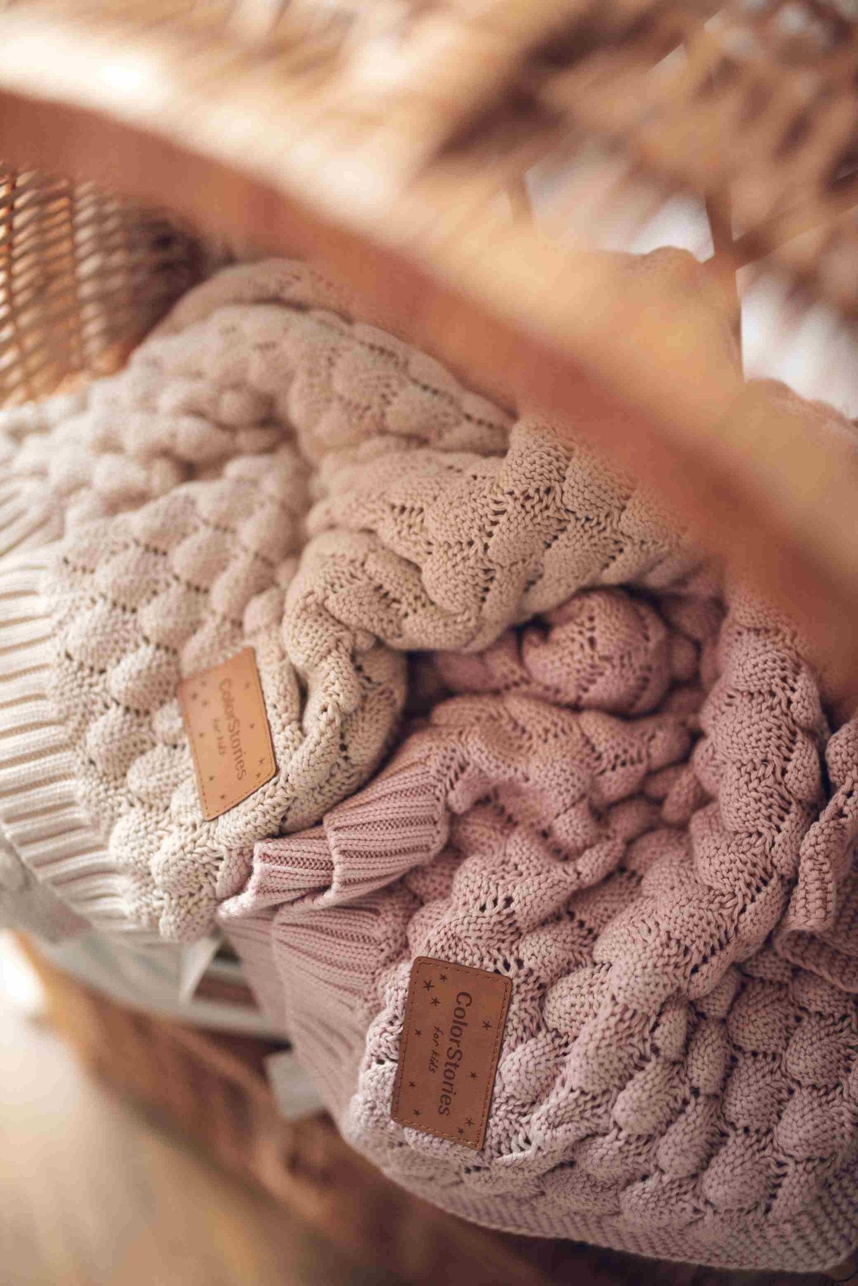Two Fema bamboo blankets, beige and misty rose, in a wicker basket