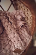 Fema bamboo blanket in misty rose in a wicker basket - knit and tag detail