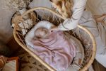 Happy Goose baby nest in a rattan basket, baby under a misty pink bamboo blanket