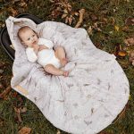 Opened Birdsong swaddle showing the bird and blossom print lining
