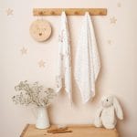 Two Happy Goose bamboo muslin cloths - goose print and dotted - on a nursery peg rail