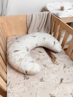 Birdsong nursing pillow on the Birdsong fitted sheet in a wooden cot