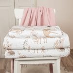 Folded Forest Friends bedding with fawns, hedgehogs and birds on a chair