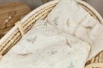 Close-up of the Birdsong pillow and duvet laid out in a wicker basket