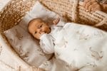 Niemowlę w koszu Mojżesza na poduszce Happy Goose, przykryte białą kołdrą w gęsi