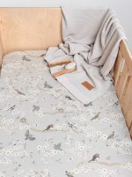 Birdsong bird print fitted sheet with a light grey blanket and a wooden brush