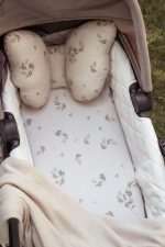Eucalyptus fitted sheet and leaf print butterfly pillow in a pram carrycot