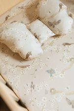 Close-up of the Birdsong Motylek pillow with a bird and blossom print