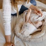 Widok z góry na niemowlę w kokonie przykryte ręcznikiem Myszka z haftowanym kapturkiem