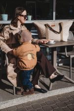 Mama z synkiem w kawiarni, obok torba do wózka XL Velvet w kolorze cappuccino