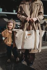 Mother and son holding the quilted XL Velvet bag in warm beige