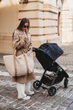 Mother with a stroller and the XL Velvet bag in warm beige on a city street