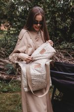 Mother putting the Herbs toiletry bag into the matching Herbs stroller bag M