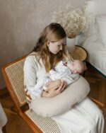 Newborn with a dummy on the Velvet nursing pillow in cappuccino - side view
